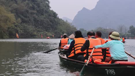 tourists rowing boats in a mountainous landscape