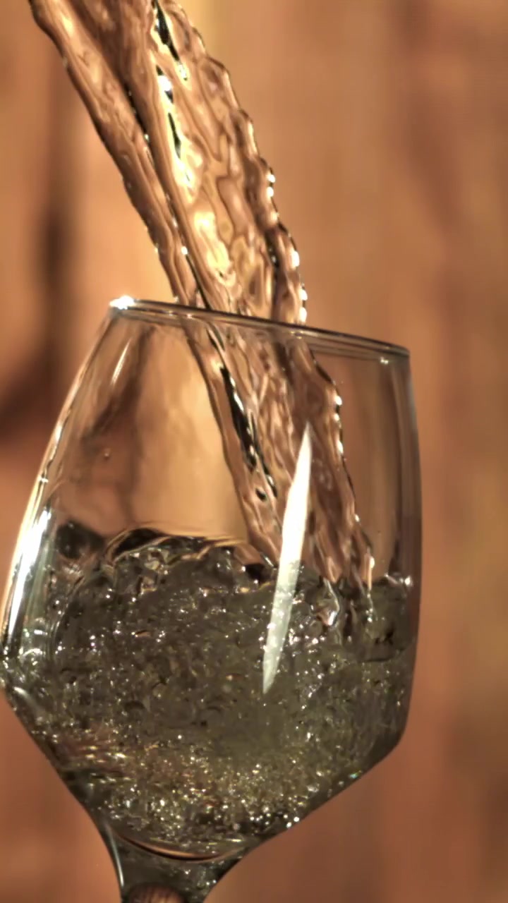 Liquido trasparente versato in un bicchiere al rallentatore