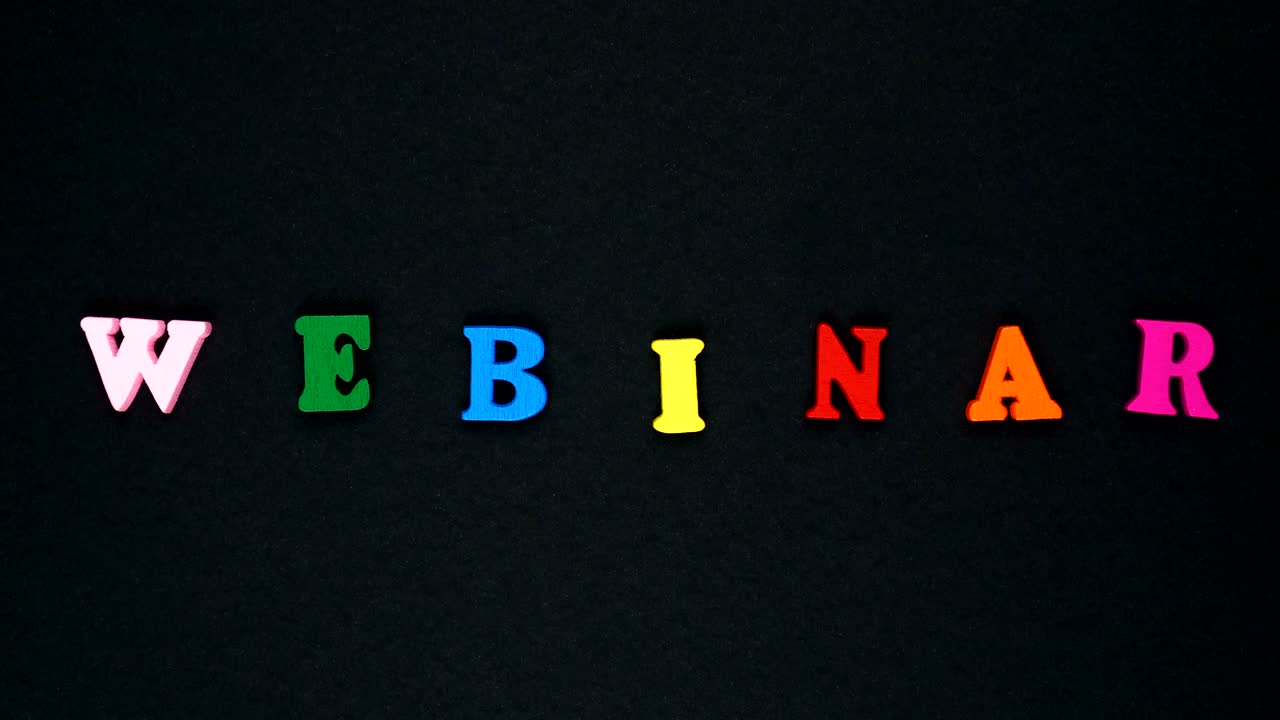 la palabra "webinar" está formada por letras de madera multicolores. palabras coloridas en bucle.