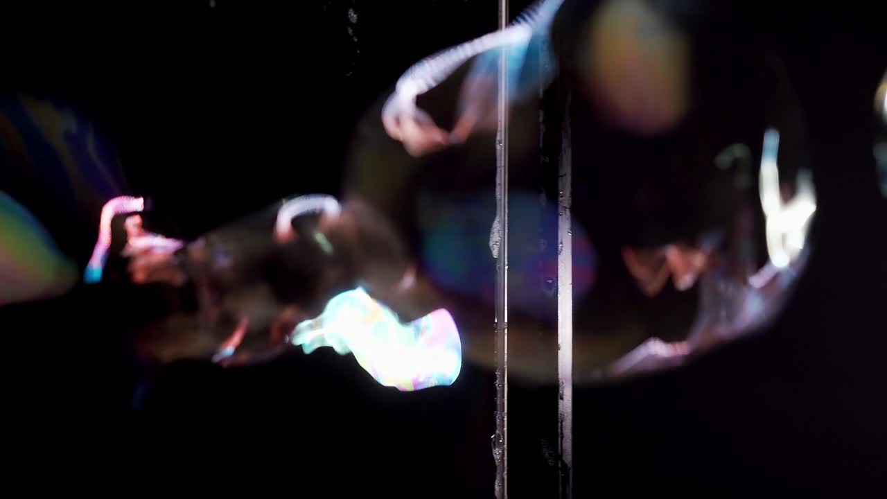 primer plano: burbujas de jabón vuelan a través de la cortina de jabón. con resaltos de color