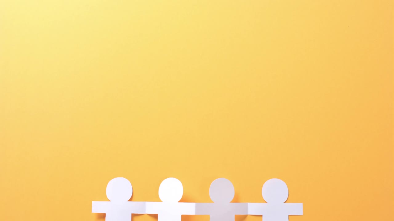 복사 공간과 함께 노란색 배경에  ⁇  종이로 만들어진 손을 잡은 사람들의 클로즈업