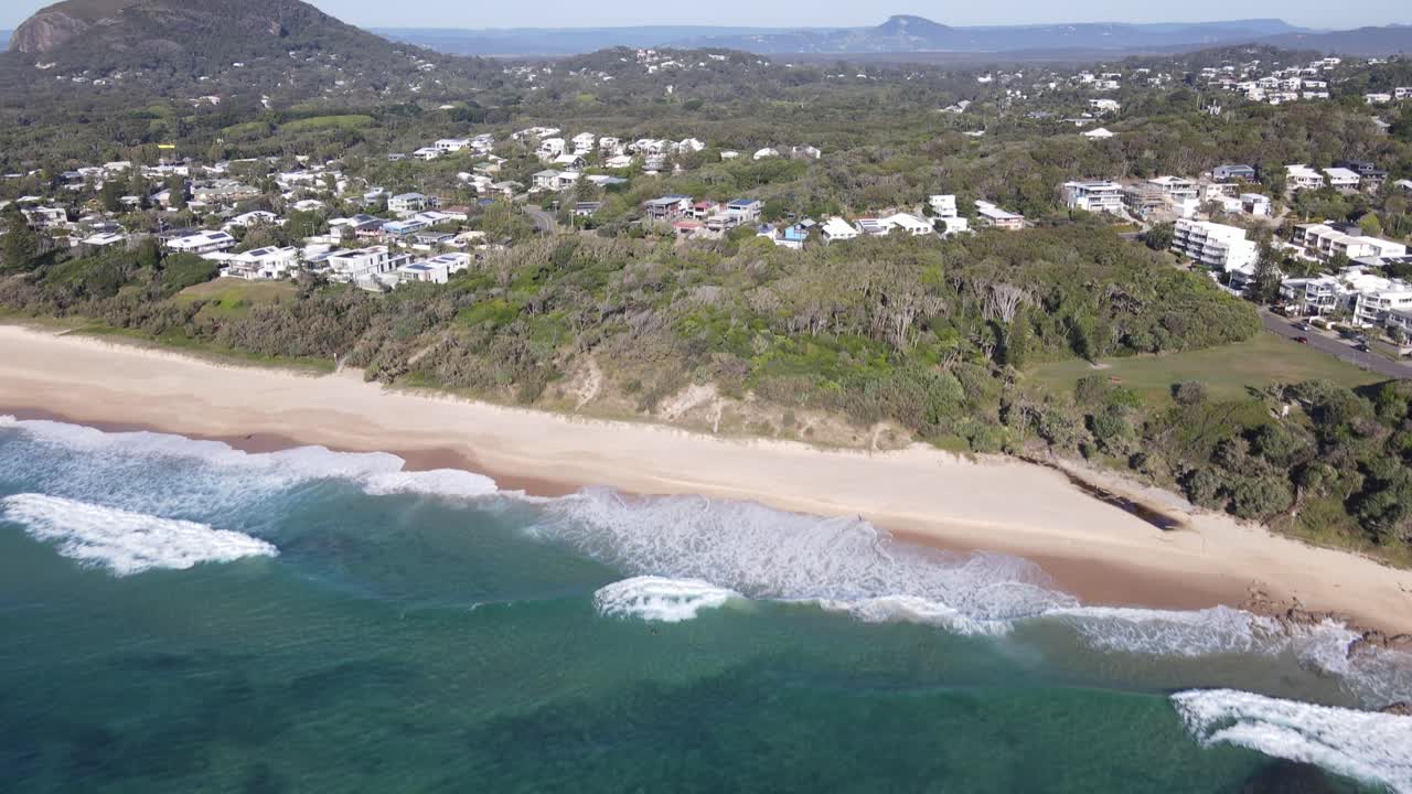 Drone aerial moving forward and rising over coolum beach and mount coolum