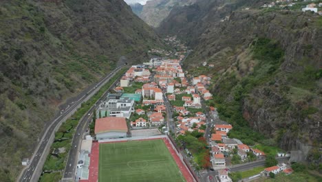 aerial of scenic town in volcanic valley in madeira, secluded between cliffs