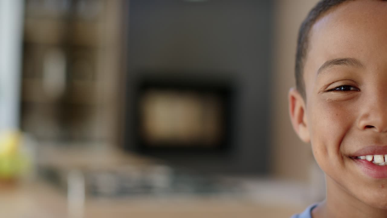 Preadolescente afroamericana che guarda la telecamera, sorridendo e ridendo, sporgendosi sul bancone in cucina, con spazio per il testo.