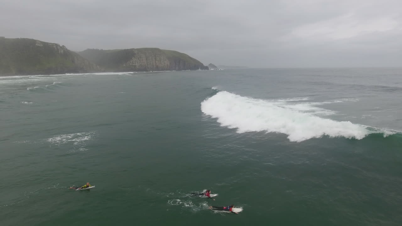 남아프리카 공화국의 커피 베이에서 서핑하는 서퍼 위로 날아가는 공중 액션 시네마틱