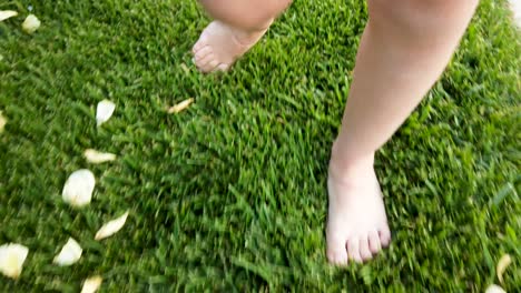 feet of little girl while walking on grass in park or garden