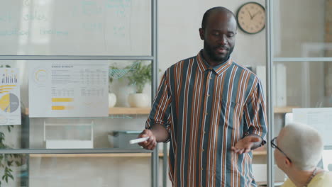 hombre afroamericano dando una presentación de negocios en una reunión de oficina