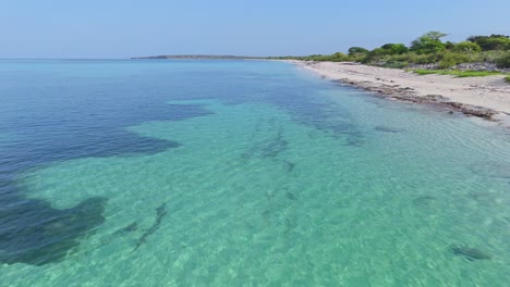 Vuelo-Aéreo-Sobre-El-Claro-Mar-Caribeño-Con-Corales-En-La-Playa-De-La-Cueva,-República-Dominicana