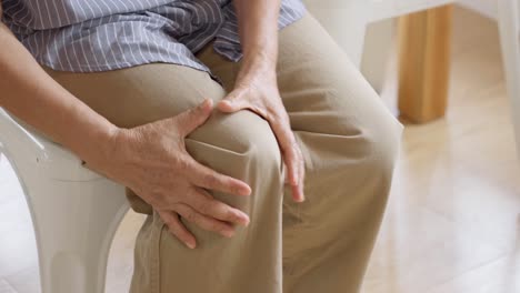 close up of old woman hands grabing on hurt knee
