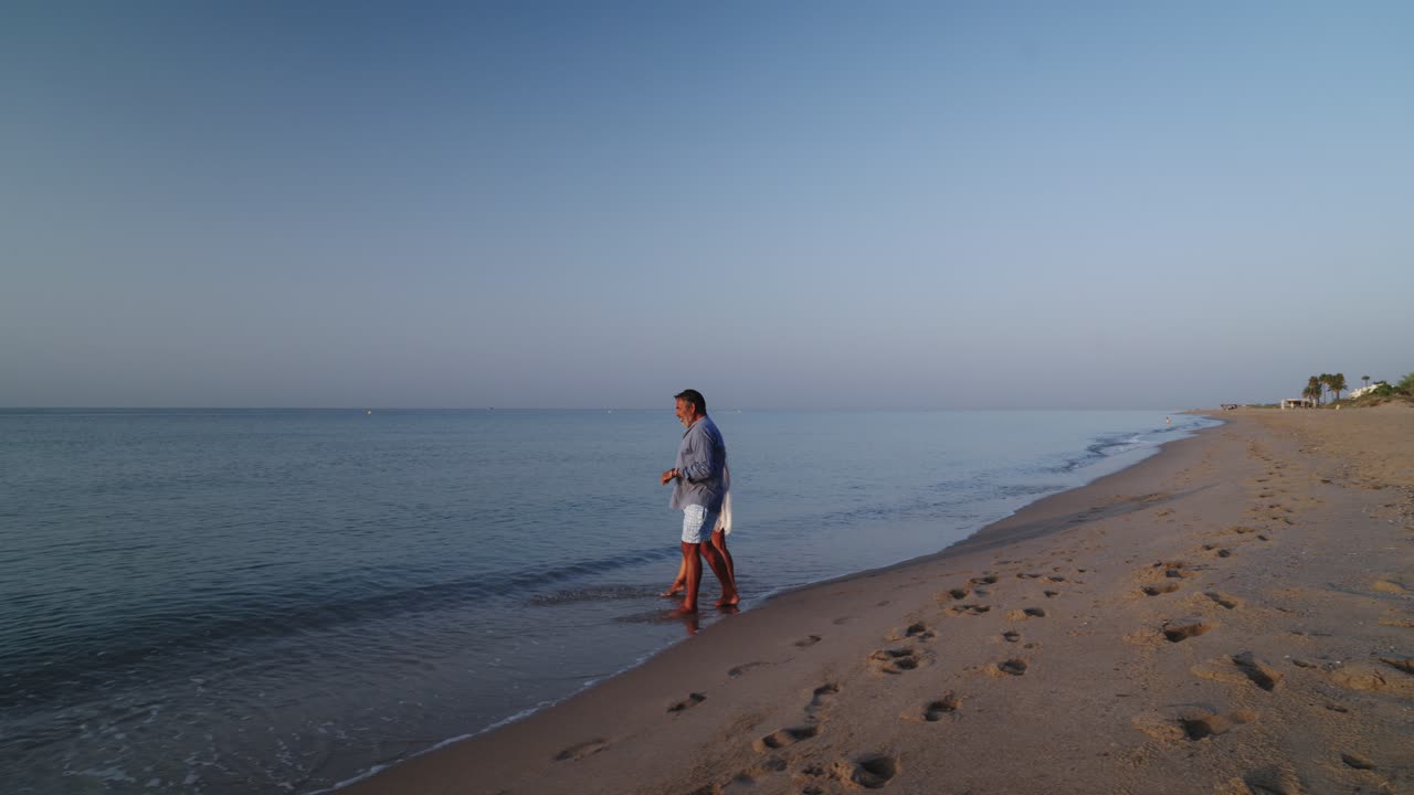 Couple walking on the beach at sunrise