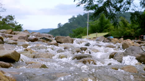 Clear-stream-running-through-stone-boulders-Abundant-river-flowing-in-slow-motion