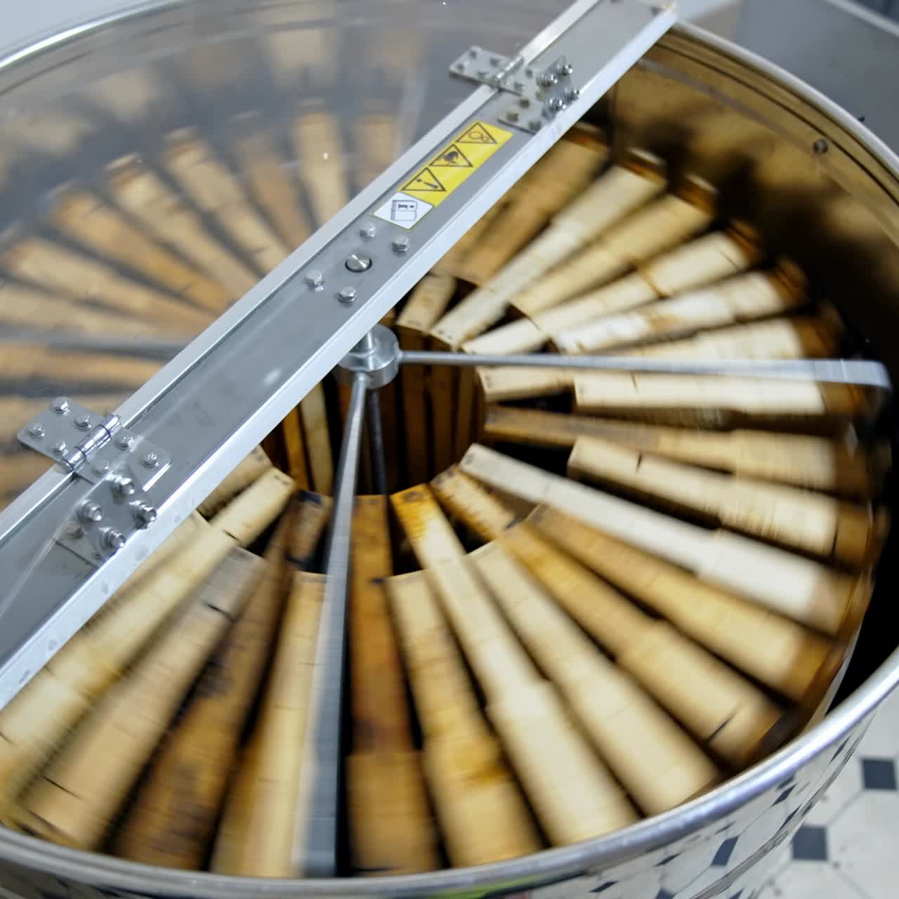Factory apiarist working with wooden beehives. Handsome man working with honey wooden frame