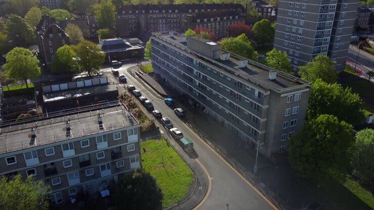 Drone che vola sopra le strade e un quartiere di case popolari nella Londra urbana.