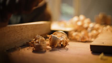 Carpenters-using-wood-planer-in-the-workshop-with-wood-waste,-closeup-of-carpenting-tools,-process-of-making-wood-furniture