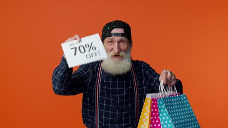 elderly bearded man showing shopping bags and up to 70 percent off inscriptions text, black friday