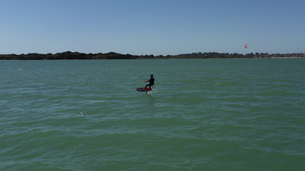 el kiteboarder surfea cerca de la playa y atrapa las condiciones de viento perfectas, toma aérea
