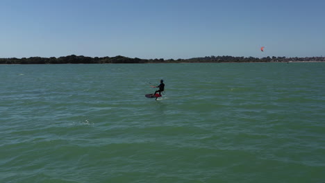 kiteboarder surfs near beach and catches perfect wind conditions, aerial shot