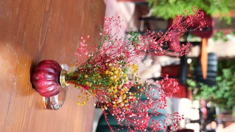 colorful dried flowers in a vase on a wooden table