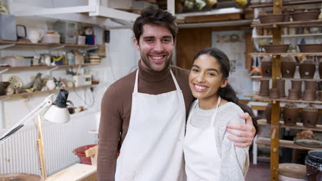 portrait of young couple wearing aprons running pottery and ceramics studio