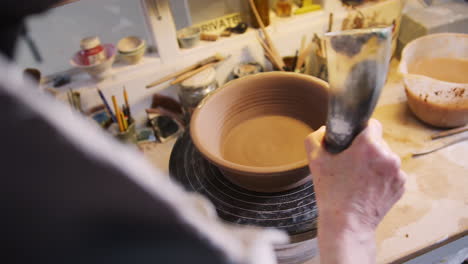 Close-Up-Of-Male-Potter-Pattern-Onto-Bread-Bowl-In-Ceramics-Studio