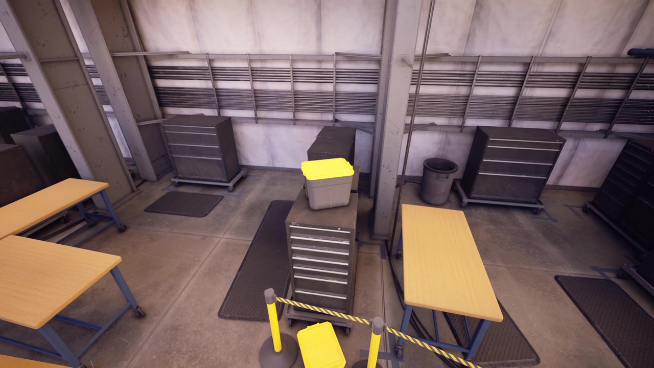 Workers preparing a workshop floor with organized tables and equipment