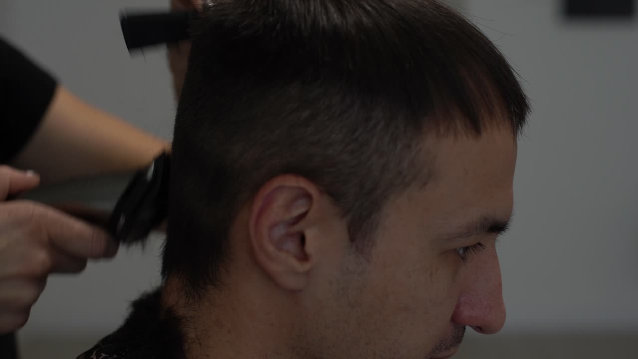 barbero cortando el cabello con un cortador