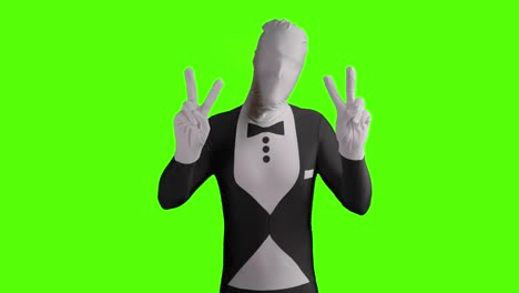 static shot of a business morphsuit demonstrating for peace and holding peace sign into camera with both hands in front of green background