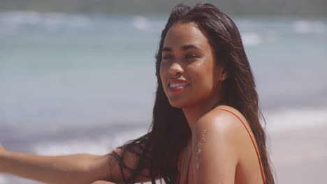 feliz sonriente morena chica latina relajándose en una suave brisa en la playa tropical, retrato