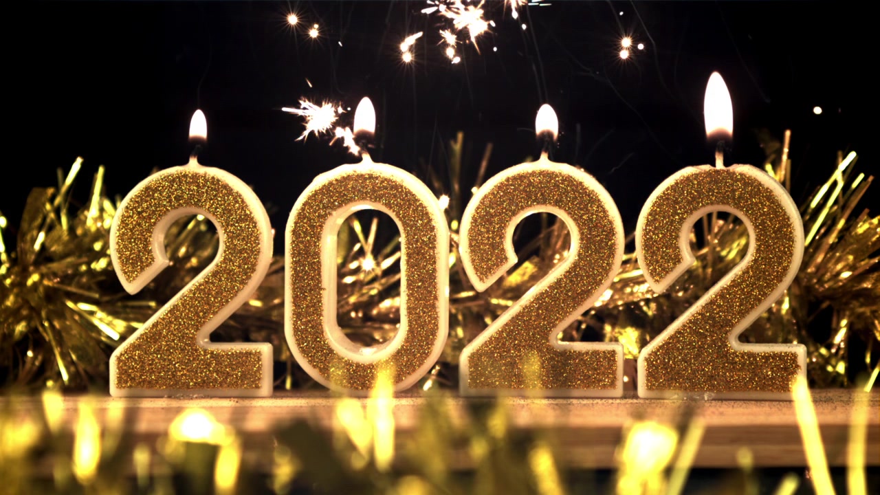Candele dorate scintillanti del 2022 che bruciano con stelle filanti per la celebrazione di Capodanno.