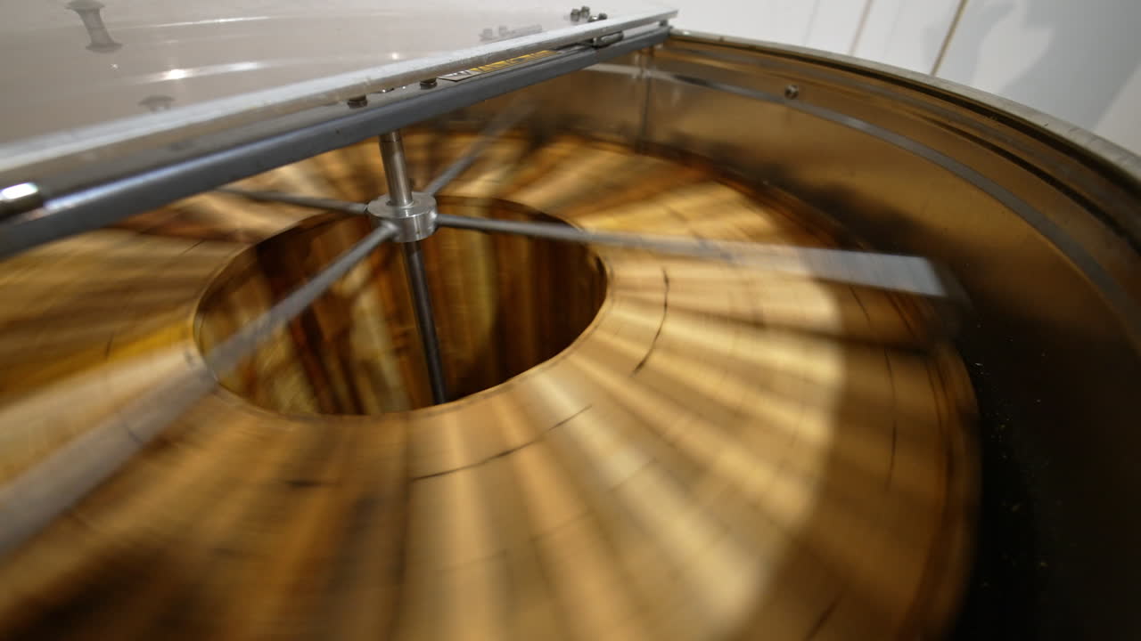 Working machine for extraction of honey at apiary. Centrifuge apparatus rotates multiple wooden frames to remove honey. Top view.