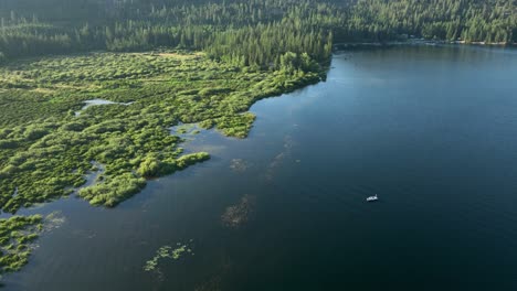 drone shot of a small fishing boat on a spirit lake, idaho