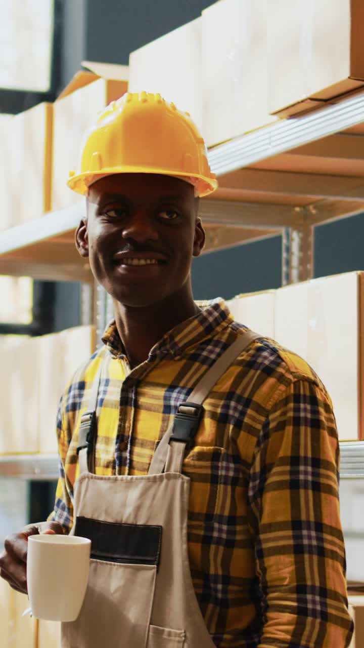 Vidéo verticale : jeune employé posant à côté de cartons sur des étagères