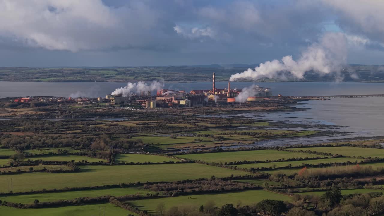 Russian-owned Aughinish Alumina refinery emitting smoke near green fields and water