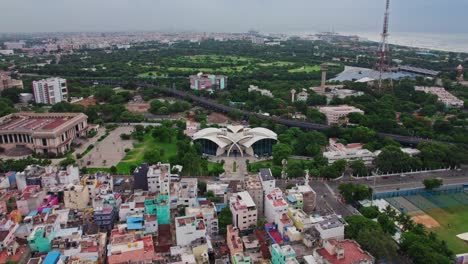 new state guest house with kalaivanar arangam and crowded buildings at wallahjah road, chennai, tamil nadu, india. day time, push back, drone shot, 4k.