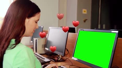 Animation-of-hearts-falling-over-woman-using-computer-with-copy-space