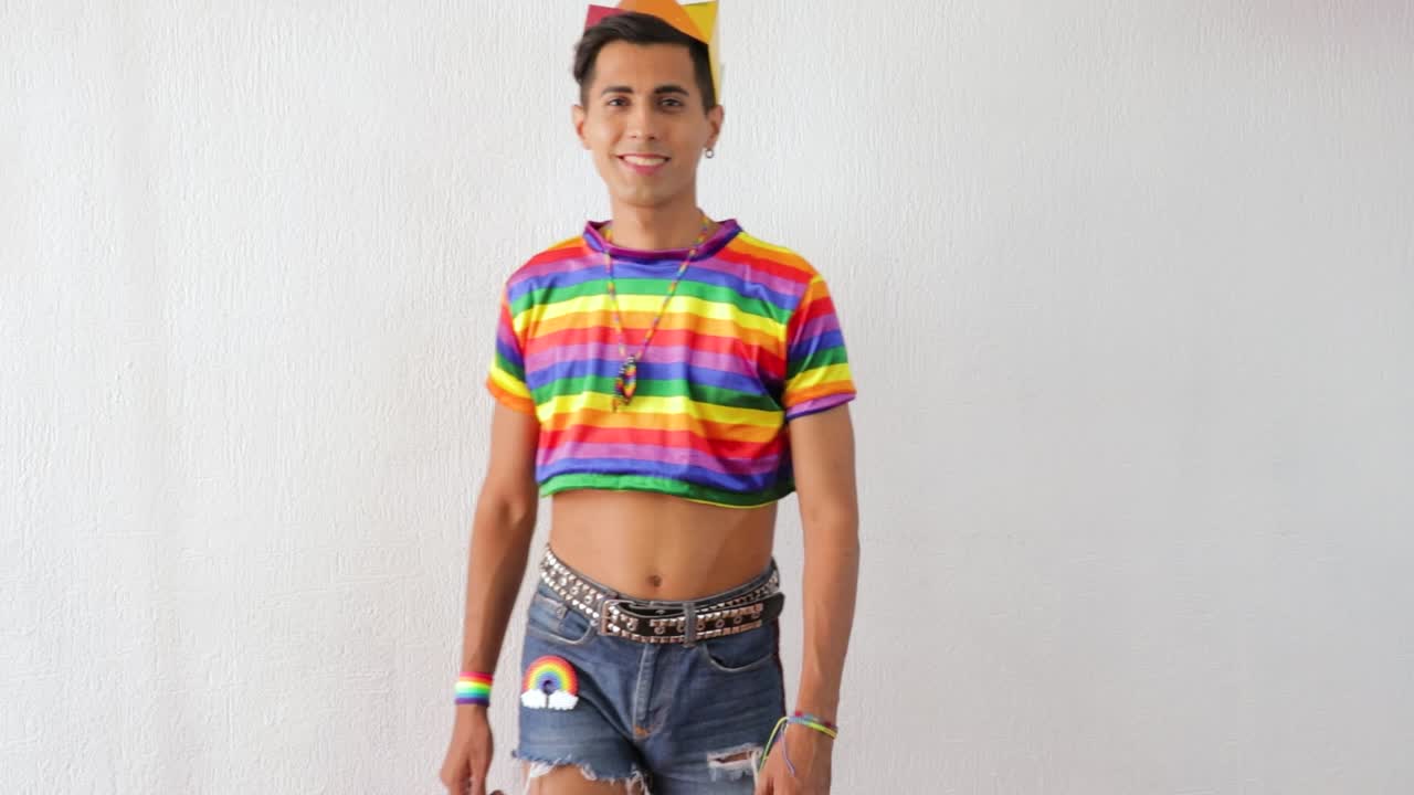 Young latino gay man wearing short jeans and rainbow LGBTQ outfit