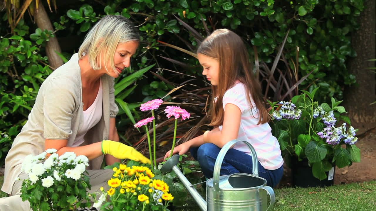 madre joven haciendo jardinería con su hija