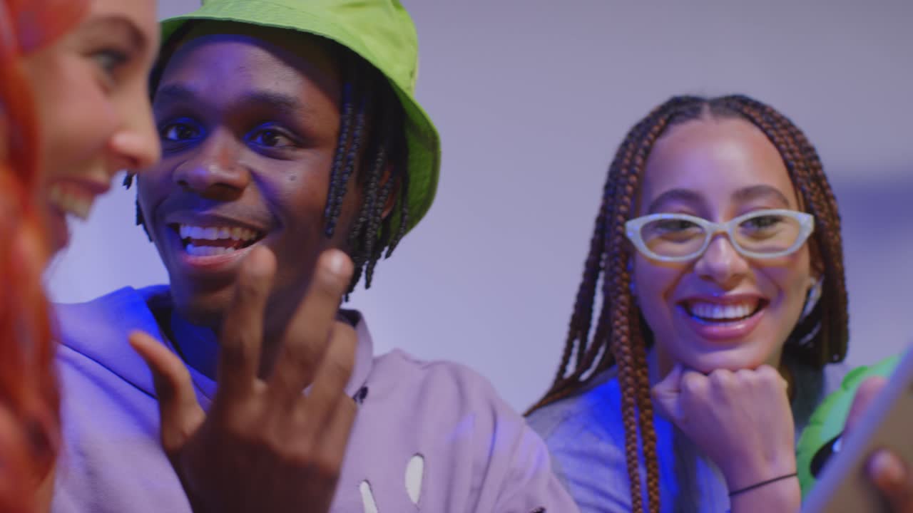 fotografía de estudio de cerca de amigos jóvenes de la generación z sentados en el sofá compartiendo publicaciones en las redes sociales en teléfonos móviles 7