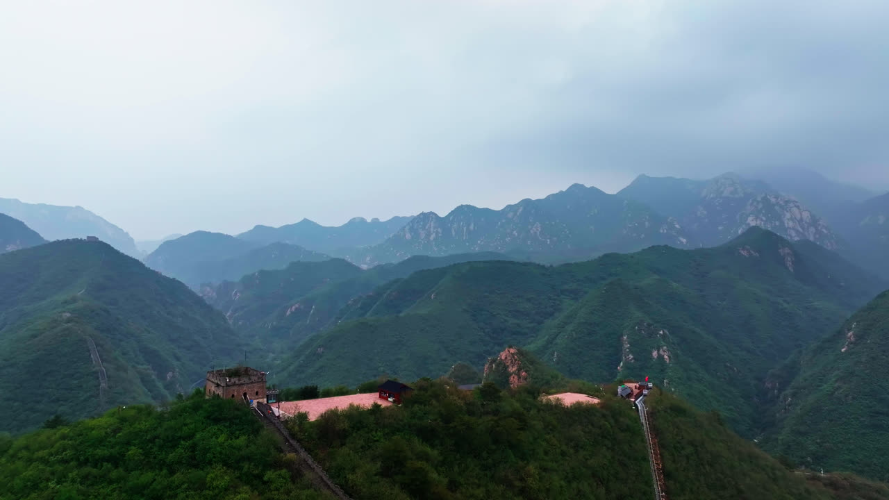 Aerial pull back revealing a watchtower in the mountains of Great Wall of China