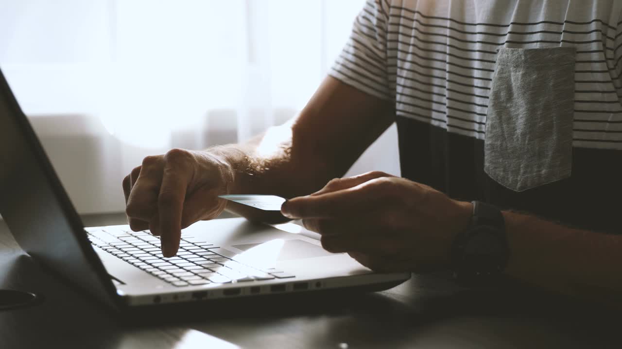 compras y pagos en línea - hombre ingresando datos de tarjeta de crédito en la computadora portátil