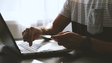 online shopping and payments - man entering credit card data in laptop