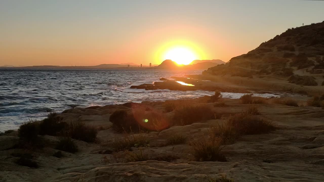 Solnedgangudsigt over den klippefyldte kystlinje ved Cabo de Huertas i Alicante, Spanien.