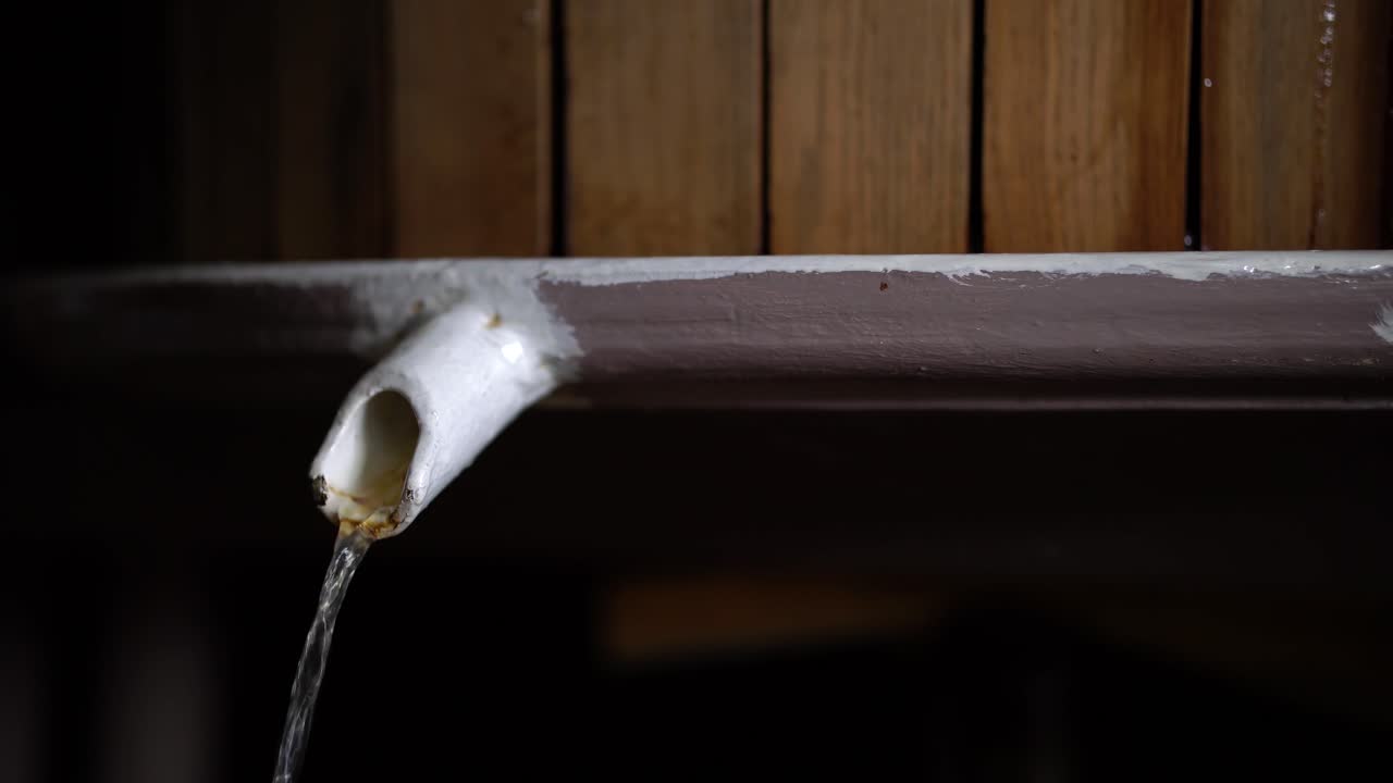 목제 와인 압착기에서 흘러나오는 맑은 포도 주스의 꾸준한 흐름을 가까이서 볼 수 있습니다.