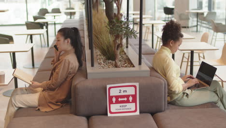 women keeping distance working in restaurant