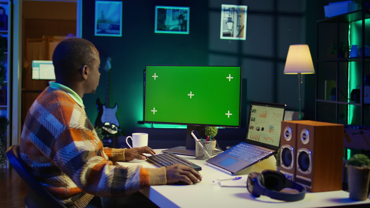 hombre trabajando en la computadora con pantalla verde