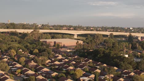 slow rotating drone footage of the speed train bridge and houses in centurion, south africa