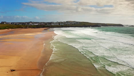 aerial drone shot over the sandy beach in newquay, cornwall, united kingdom