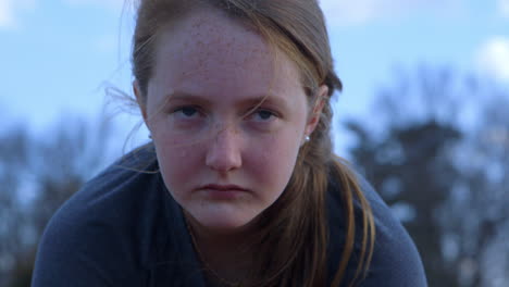 closeup of a girl's face as she stares intently past camera