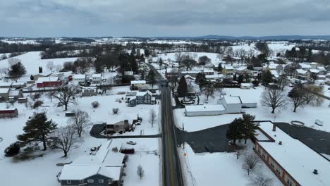 Disparo-De-Un-Dron-De-Aterrizaje-Que-Muestra-La-Calle-Principal-Del-Barrio-Suburbano-En-La-Nieve-Del-Invierno.