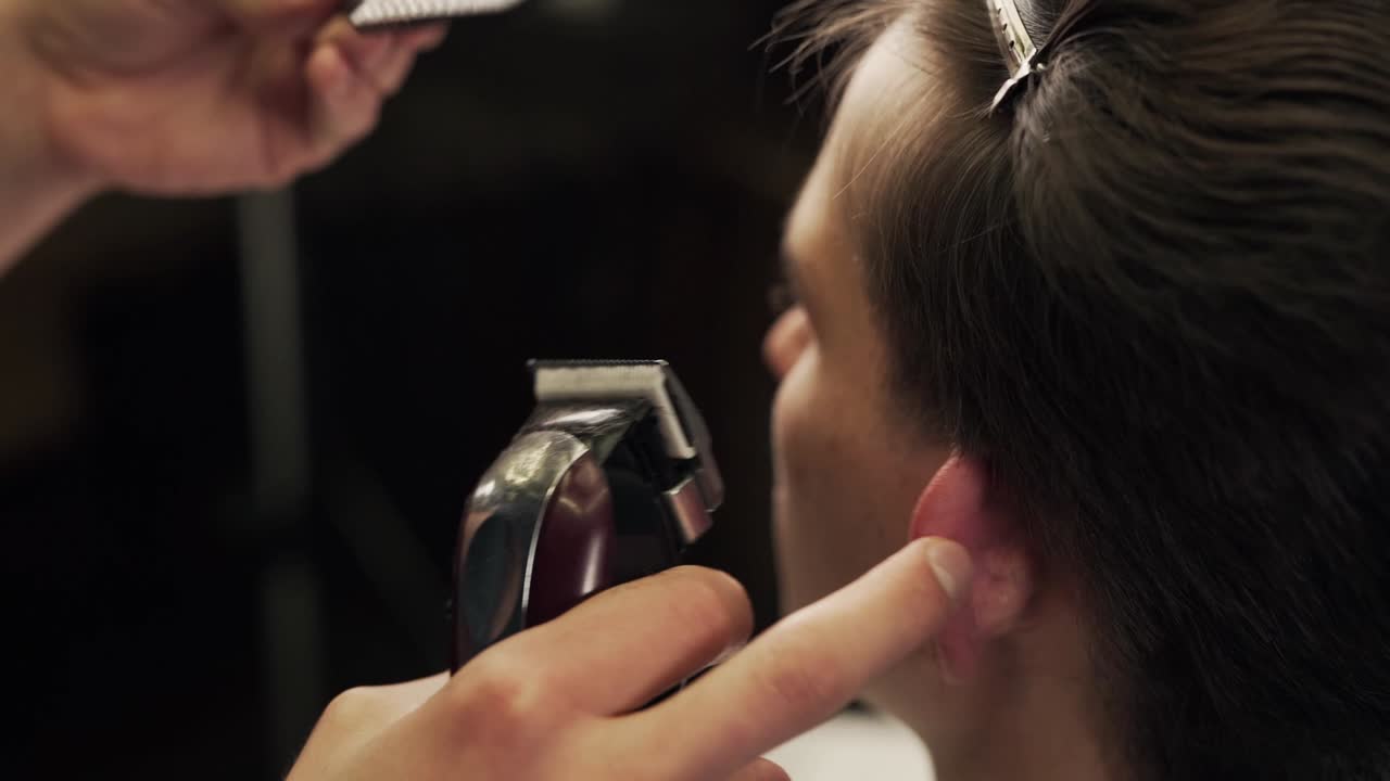 close-up male hands of a master typewriter cutting hair on a comb